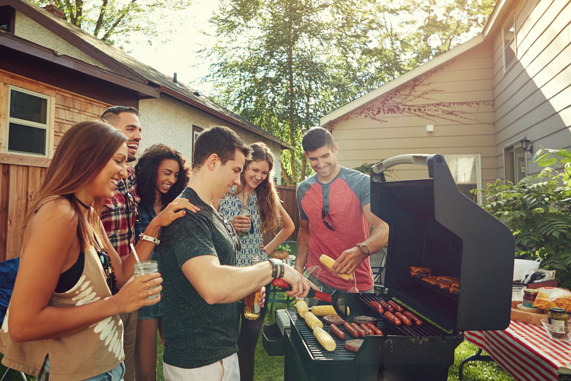 Neighbors gathered in a warmly-lit backyard at sunset